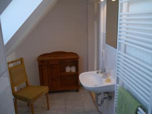 a small bathroom with a sink and a chair at Ferienhaus-Uckermarkblick in Rosenow
