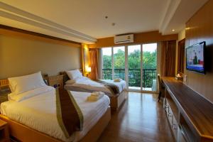 a hotel room with two beds and a flat screen tv at Kitlada Hotel Udonthani in Udon Thani