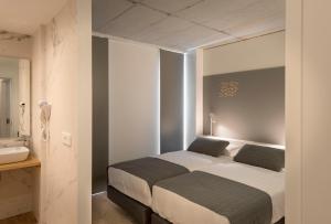 ein Schlafzimmer mit zwei Betten und einem Waschbecken in der Unterkunft Hotel SempreFisterra in Kap Finisterre
