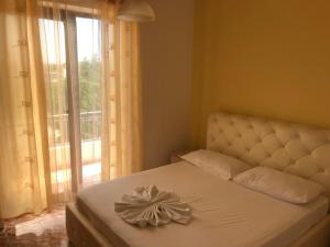 a bed with a bow on it in front of a window at Hotel President in Golem