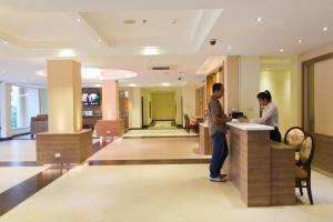 two people standing at a counter in a hotel lobby at Kitlada Hotel Udonthani in Udon Thani