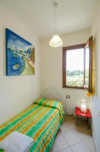1 dormitorio con cama y ventana en A.I.R. Castelsardo Borgo di Mare en Castelsardo