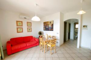 sala de estar con sofá rojo y mesa en A.I.R. Castelsardo Borgo di Mare en Castelsardo