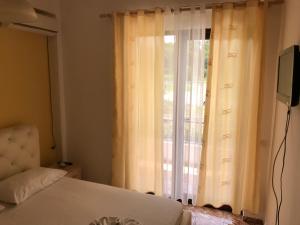 a bedroom with a bed and a window with curtains at Hotel President in Golem +55 photos