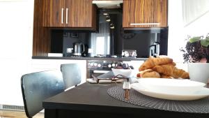 a kitchen with a table with a bowl of bread at Royals Flower Apartments III in Krakow