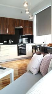 a living room with a couch and a kitchen at Royals Flower Apartments III in Krakow