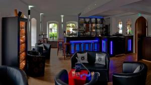 un bar avec des chaises noires et un bar bleu dans l'établissement Hotel Bedburger Mühle, à Bedburg