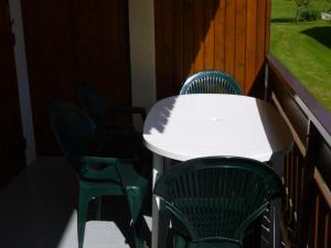 - une table et des chaises blanches sur une terrasse couverte dans l'établissement le -charvin, au Grand-Bornand