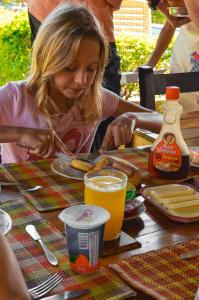 蒙特内哥罗Finca Hotel el Palmar的一位女士坐在桌边，面前摆着一盘食物