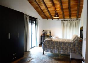 um quarto com uma cama e uma grande janela em Casa Rural El Abuelo Alonso em La Codosera