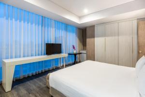 a bedroom with a bed and a desk with a television at Crowne Plaza Barranquilla, an IHG Hotel in Barranquilla