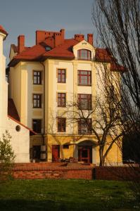 un gran edificio blanco con techo rojo en Arte en Brzeg