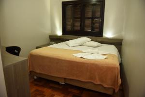 a bedroom with a bed with two towels on it at Hotel Lages in Tabapira