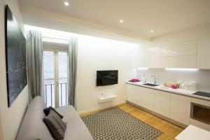 una cucina bianca con divano e tavolo di Apartment Via del Corso a Roma
