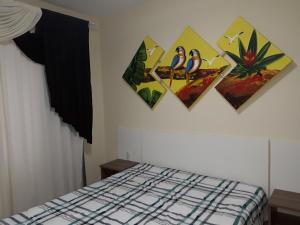 a bedroom with four pictures on the wall and a bed at Ótimo Apto. 180 metros da Praia in Balneário Camboriú