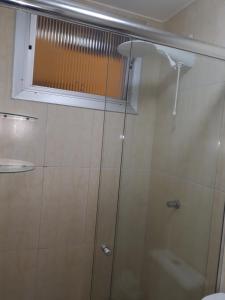 a shower with a glass door and a window at Ótimo Apto. 180 metros da Praia in Balneário Camboriú +13 photos