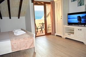 a living room with a television and a balcony at Villa Dulcinea in Ulcinj