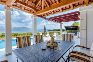 a dining table on a patio with a view of the ocean at Villa Dada in Supetar