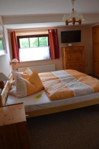 a large bed in a bedroom with a window at Hotel garni & Oma's Heuhotel 'Pension zur Galerie' in Barby