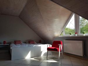 ジヴィエツにあるNiewinne domki - Burgundiaの屋根裏のベッドルーム(ベッド1台、赤い椅子付)