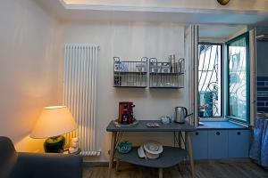 une chambre avec une table, une lampe et une fenêtre dans l'établissement Serendipity, à Salerne
