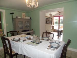 a dining room with a white table with chairs at Chez Clemley in Lezay