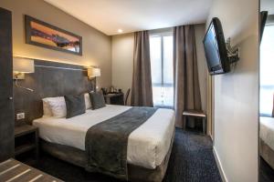 a hotel room with a bed and a flat screen tv at Hotel Paris Italie in Paris