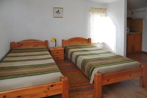 two beds sitting next to each other in a room at Guest House Maija in Ventspils