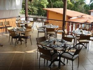 a restaurant with tables and chairs on a patio at Pousada Vila Cocais in Cocais