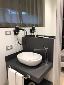a bathroom with a white sink on a black counter at Ex-L in Fiume Veneto