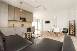 a living room with a couch and a dining room at Holiday House Palanga with Hot Tub in Palanga +20 photos