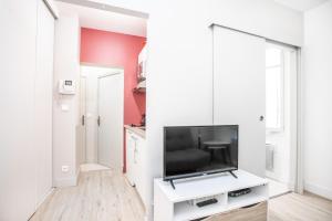 uma sala de estar com uma televisão de ecrã plano numa parede branca em Appartement 3 - tout équipé - Carmes, Toulouse em Toulouse