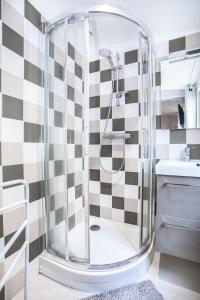 La salle de bains est pourvue d'une douche et de carrelage noir et blanc. dans l'établissement Appartement 8 - tout équipé - Carmes, Toulouse, à Toulouse