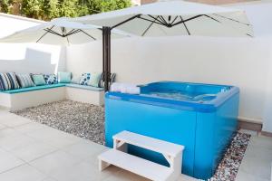 bañera de hidromasaje azul con sombrilla y banco en Le Stanze Del Duomo en Lecce