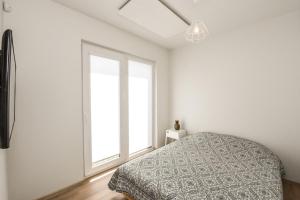 a bedroom with a bed and a large window at Holiday House Palanga with Hot Tub in Palanga