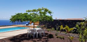 a patio with a table and chairs next to a pool at Casa De La Vaca in Mazo