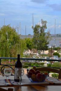 a table with a bowl of fruit and a bottle of wine at Prokimea Seaview Apartments in Lefkada