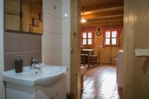 a bathroom with a sink and a kitchen with a table at Kuća za odmor Cindrić in Slunj
