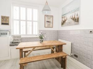 a kitchen with a wooden table in a room at Sefton Cottage in Deganwy