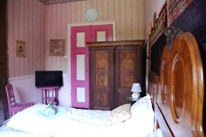 a bedroom with a bed and a pink door at Casa Memoriala George Stephanescu in Căpăţîneni-Ungureni