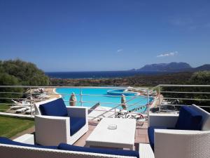 a large swimming pool with a balcony overlooking the ocean at Hotel Luna Lughente in Olbia