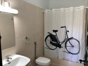 a bathroom with a bike hanging on the shower curtain at Cactus Hostel in San Sebastián de la Gomera