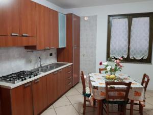 a kitchen with a table and a sink and a stove at Domus Elisa in San Cipriano Picentino