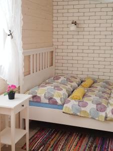 a bedroom with a bed and a white brick wall at Apartamenty przy winnicach in Bogács