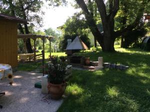 a garden with a grill and a tree in the grass at Haus Judith in Steindorf am Ossiacher See