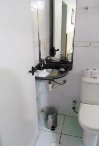 a bathroom with a sink and a mirror at Titão Plaza Hotel in Campina Grande