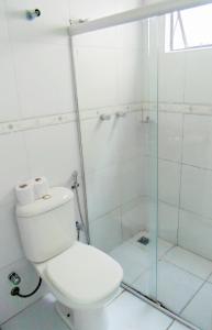a bathroom with a toilet and a glass shower at Titão Plaza Hotel in Campina Grande