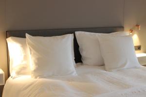 a bed with two white pillows on top of it at MAIO B&B en Dinner in Zonhoven