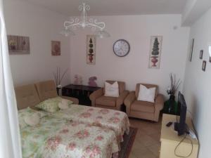 a bedroom with a bed and two chairs and a clock at Ai tre archi di Tagliaborse in Mascali
