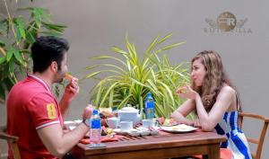 a man and woman sitting at a table eating food at Ruth Villa in Negombo